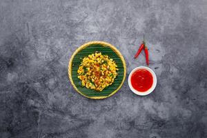 Fried corns with bacons with chili sauce served in bowl isolated on dark grey background top view of japanese food photo