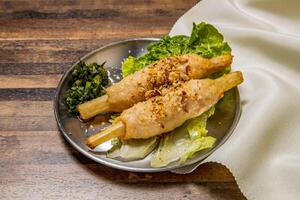 Vietnamese Sugar Cane with Shrimps with lettuce leaf and spring onion served in dish isolated on wooden table top view of hong kong fast food photo