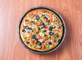 Chicken Fajita Pizza isolated on wooden background, spiced chicken cubes and cheese combination on bread, Italian food top view photo