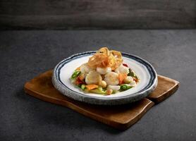 Assorted Vegetables with Scallops served in a dish isolated on mat side view on dark background photo