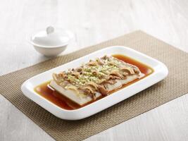 Steamed Spring Water Tofu with Shrimp Paste and Pork Belly with chopsticks served in a dish isolated on mat side view on grey background photo