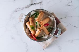 fried spring roll with salad and noodles in a dish isolated on mat top view on grey marble background photo