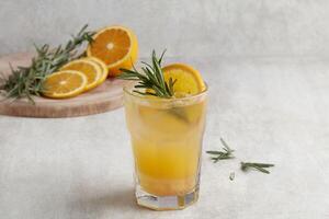Fresh summer orange cocktail soda with lemons, mint and ice on grey background photo