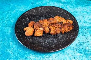 spicy bbq chicken tikka boti kabab served in a dish isolated on background top view photo