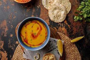 bahraini rojo lenteja sopa con Lima y un pan servido en plato aislado en mesa parte superior ver de Arábica desayuno foto