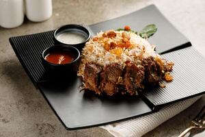 Mutton Biryani with raita and sauce served in a dish isolated on grey background side view fast food photo