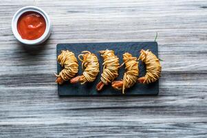 Shrimp Caught In Noodle Net with tomato sauce isolated on wooden board top view on table fastfood photo