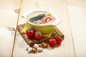 Fish soup with tomato, ginkgo and wolfberry served in a bowl isolated on napkin side view of hong kong food photo