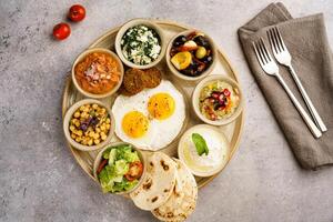 Lebanese Breakfast with hummus, salad, sunny egg, chickpeas, bread served in dish isolated on table top view of arabic breakfast photo