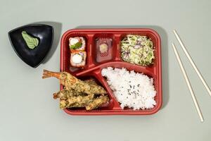 MIXED TEMPURA regular BENTO with sauce and chopsticks isolated on red background top view of japanese fast food photo