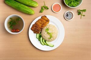 Chicken Cutlet Rice with raw cucumber, Coriander, salad, sauce and soup served in a dish isolated on wooden background top view photo