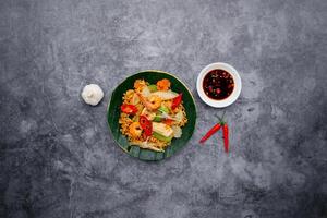 Seafood prawn Fried Noodle with salad and fish sauce served in bowl isolated on dark grey background top view of japanese food photo