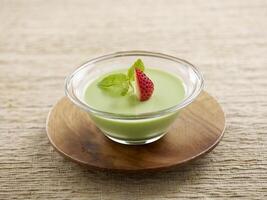 Avocado Pudding Served in a bowl isolated on wooden board side view on grey background photo