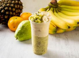 Kiwi Banana milkshake served in disposable glass isolated on background top view taiwan food photo