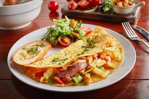 Hash Gouda omelette roll with salad served in a dish isolated on wooden background side view photo