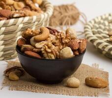 clásico mezclado nueces servido en un cuenco aislado en servilleta lado ver de nueces en gris antecedentes foto