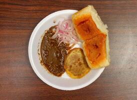 Sauth asian food bun and kabab With Tomato Sauce and Spicy Chutney in white plate isolated on dark wooden table famous Pakistani, Indian, Bangladeshi food photo