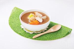 Pork tendon soup with scallops, snails, lily and sweet potato served in a bowl isolated on napkin side view of hong kong food photo