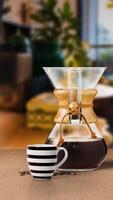 CHEMEX COFFEE maker filter with black coffee cup isolated on table side view photo