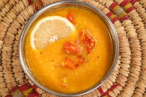 Daal lentil Soup with lemon served in bowl isolated on background top view arabic style photo