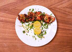 chicken malai tikka boti with lemon slice served in dish isolated on grey background top view of pakistani food photo