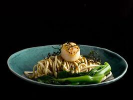 Pan Fried Fish Paste Noodle with Scallop served in dish isolated on table top view of food photo