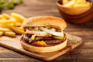 especial carne de vaca hamburguesa con papas fritas servido en un corte tablero aislado en de madera mesa lado ver de comida rápida foto