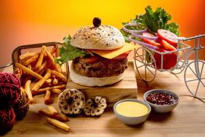 carne de vaca queso hamburguesa con francés papas fritas, patata y tomate rebanada aislado en de madera tablero diapositiva ver en mesa rápido comida foto