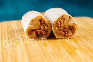 Chicken shawarma roll wrap isolated on wooden board side view of fastfood photo