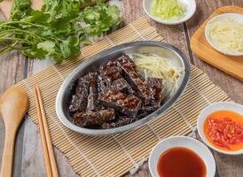 caramel rice roll bars with chilli sauce, noodles, spoon and chopsticks served in dish isolated on napkin top view of hong kong food photo