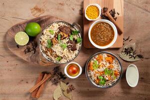 Indian spicy mutton Biryani and chicken biryani with gravy, raita and gulab jamun Served in a dish side view on grey background photo