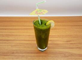 Fresh and cool mint margarita with lemon slice and straw served in a glass isolated on grey background side view of indian, pakistani food photo