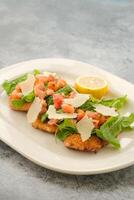 Specialty Chicken Milanese with salad and lime served in a dish isolated on background side view of fastfood photo