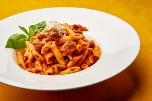 Penne Sausage Pasta served in dish isolated on table top view of arabic tasty fasfood photo