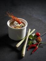 Tom Yum Seafood Soup served in a dish isolated on mat side view on grey background photo