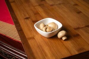 Fresh Mushroom served in bowl isolated on wooden table top view of indian food photo