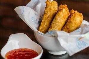 MOZZARELLA STICKS with chilli sauce served in a dish isolated on table side view photo