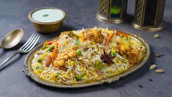 Paneer Butter Masala Biryani with raita served in a dish side view on dark background photo