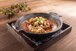 Spicy beer beef offal pot served dish isolated on wooden table top view of Hong Kong food photo