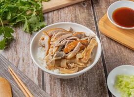 Duck Meat Rice with chilli sauce, noodles, spoon and chopsticks served in dish isolated on napkin top view of hong kong food photo