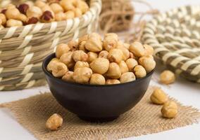 hazelnut served in a bowl isolated on napkin side view of nuts on grey background photo