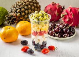 mixed juice of kiwi, durian, tomato, pears and plum with raw fruits served in disposable glass isolated on background top view taiwan food photo