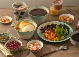 assorted Red Bean Rice Balls, Taro Balls, bean curd, brown sugar shaved ice, Grass Jelly Iced Milk Tea, burn jelly, egg and chocolate pudding served in dish isolated on table top view of taiwan food photo