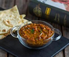 middle eastern food foul medames with bread served in a dish isolated on cutting board side view of breakfast on wooden background photo