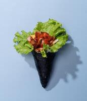 SPICY TUNA wrap topping with salad leaves isolated on sky blue background top view fast food photo