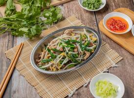 Duck intestines mixed vegetables with chilli sauce, noodles, spoon and chopsticks served in dish isolated on napkin top view of hong kong food photo