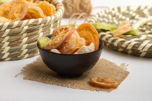 Thai dried fruits served in bowl isolated on napkin side view of dry fruits on grey background photo