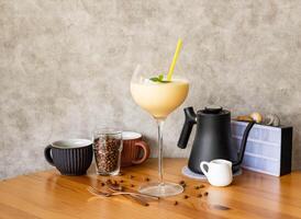 Fresh Fruit Mango Milkshake with coffee beans, fork, spoon served in glass isolated on wooden table top view of taiwan food photo