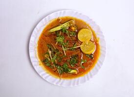 chicken nihari with lemon slice served in plate isolated on grey background top view of pakistani food photo