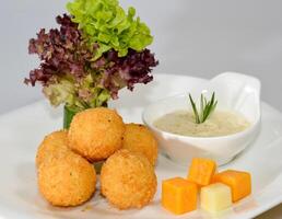 Cheese balls with dip served in a dish isolated on table side view photo